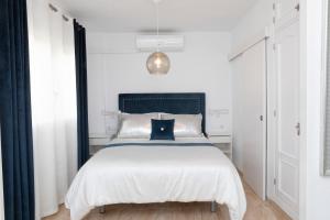 a bedroom with a white bed with a black headboard at Acapulco playa Nerja 407 planta superior in Nerja