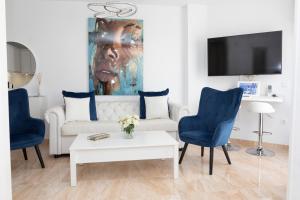 a living room with a white couch and blue chairs at Acapulco playa Nerja 407 planta superior in Nerja