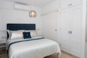 a white bedroom with a bed and white cabinets at Acapulco playa Nerja 407 planta superior in Nerja +37 photos