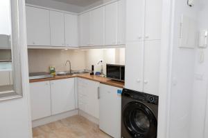 a kitchen with white cabinets and a washer and dryer at Acapulco playa Nerja 407 planta superior in Nerja