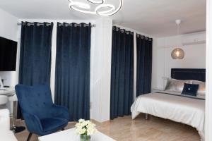 a bedroom with a bed and a blue chair at Acapulco playa Nerja 407 planta superior in Nerja