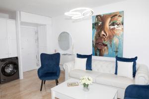 a living room with a white couch and a painting at Acapulco playa Nerja 407 planta superior in Nerja