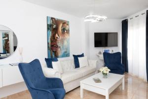 a living room with a white couch and blue chairs at Acapulco playa Nerja 407 planta superior in Nerja