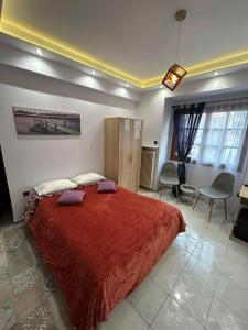 - une chambre avec un grand lit et une couverture rouge dans l'établissement Ano Poli Studios 1, à Thessalonique
