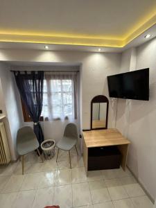 uma sala de estar com uma secretária e uma televisão na parede em Ano Poli Studios 1 em Tessalônica