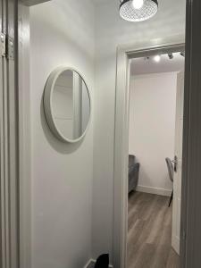 a bathroom with a mirror on a white wall at Flat in Luton Town Centre in Luton