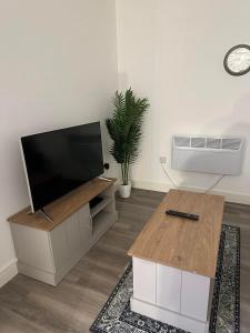 a living room with a flat screen tv and a coffee table at Flat in Luton Town Centre in Luton