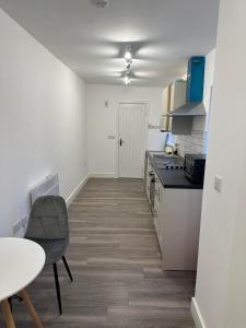 a white kitchen with a table and a counter top at Flat in Luton Town Centre in Luton