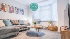 a living room with a couch and a clock on the wall at The Hideout - free parking in Southampton