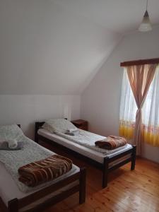 een slaapkamer met 2 bedden en een raam bij Vila Ivana in Mitrovac