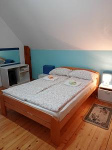 a large bed in a room with a wooden floor at Vila Ivana in Mitrovac