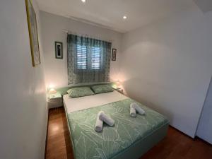 a bedroom with a bed with two slippers on it at Biljana Ivanisevic Apartments in Jelsa