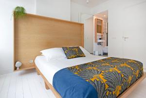 een slaapkamer met een groot bed met een houten hoofdeinde bij Happy guesthouse in Brussel