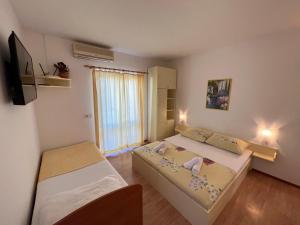 Habitación pequeña con 2 camas y ventana en Biljana Ivanisevic Apartments, en Jelsa