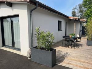 una casa con patio arredato con tavolo e sedie di Gujan-Mestras Chez Flo maison 4 places la hume a Gujan-Mestras