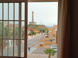 a window with a view of a street and a monument at 2 Rooms Vistas al Mar Piscina in Cabo de Palos