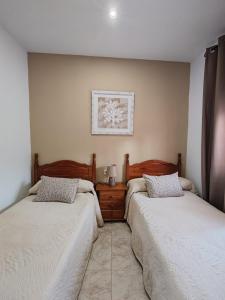 two beds sitting next to each other in a bedroom at Casa Fregenal Centro R&S in Fregenal de la Sierra