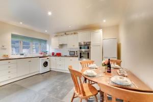 a kitchen with a table and chairs and a kitchen with white cabinets at Pandy Barn Berriew in Welshpool