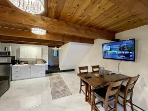 a kitchen and dining room with a table and a tv at Waterfront Hot Tub Firepit King Bed - 6h in Ucluelet
