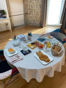 a white table with breakfast foods on it at Le Cocon de Curson chambre d'hôtes in Chanos-Curson