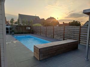 a swimming pool in a backyard with a fence at Twinkeling Lights in Kluisbergen