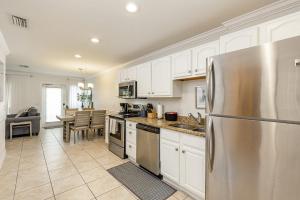 a kitchen with white cabinets and a stainless steel refrigerator at Heat of Siesta Village Walk to Beach w heated Pool in Siesta Key