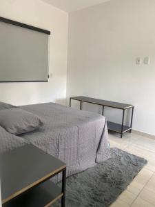 a bedroom with a bed and a black table at VILLAGE Host Hotel in Pedra Bela