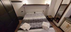 バルツィオにあるMountain lodging with fireplace and mountain viewの小さな部屋で、ベッド2台、鏡が備わります。