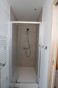 a shower in a bathroom with a glass door at La Grotte Bourguignonne, Terrasse extérieure in Dijon