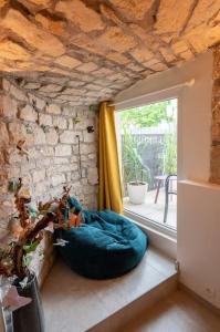 a room with a window and a blue dog bed at La Grotte Bourguignonne, Terrasse extérieure in Dijon