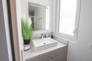 a bathroom with a white sink and a mirror at La Grotte Bourguignonne, Terrasse extérieure in Dijon