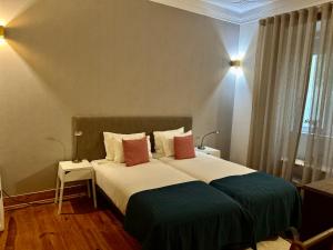 una camera da letto con un grande letto con due cuscini di Bairro Alto a Lisbona