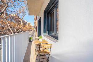 a balcony with a wooden table and chairs at ApartsNouBcn Equador Les Corts in Barcelona