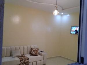 a living room with a couch and a tv on a wall at Appartement à louer Tiznit 2 in Tiznit