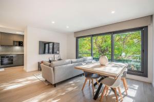 a living room with a couch and a table at ApartsNouBcn Equador Les Corts in Barcelona