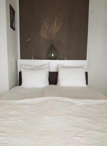 a large bed with white sheets and pillows at Appartement Zuid 5 in Zandvoort