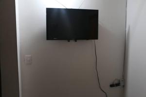 TV de pantalla plana en la parte superior de una puerta blanca en Aparta Suite Torre De Prado 303, en Medellín