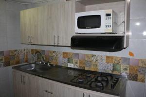 cocina con fregadero y microondas en Aparta Suite Torre De Prado 303, en Medellín