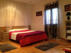Un dormitorio con una cama roja y blanca y una ventana en Estudios Blanmart, en Santander