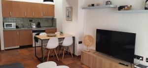 une cuisine avec une télévision et une table avec des tabourets dans l'établissement Apartamento Nevada Sur, à Sierra Nevada