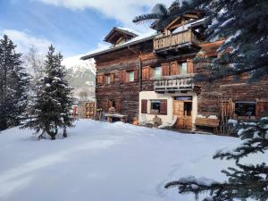 una baita di tronchi con neve di fronte di Silva: The Alpine Chalet a Livigno