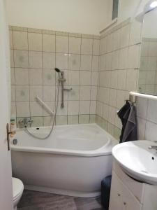 uma casa de banho com uma banheira, um WC e um lavatório. em Aréna Apartman em Kaposvár