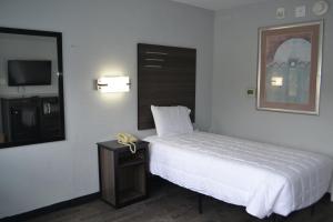 Un dormitorio con una cama, un espejo y una mesa. en Noble Suites Jacksonville, en Jacksonville