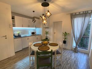 布爾奇科的住宿－Kula Apartman 2，厨房以及带桌椅的用餐室。