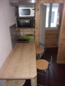 a tiny house with a table and a microwave at Logement proche de tout in Saint-Laurent-de-Neste