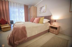 a bedroom with a bed and a chair and a window at Apartamenty na Wyspie - Villa Pegaz - Parking in Świnoujście +214 photos