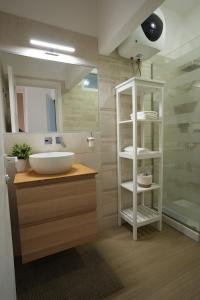 a bathroom with a white sink and a shower at Luxury Rooms Paoli 19 in Cagliari