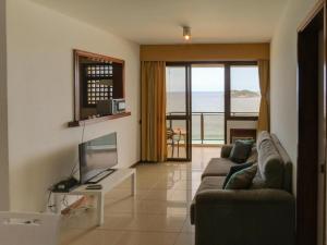sala de estar con sofá y TV de pantalla plana en Apart Hotel Barra Leme com Vista Mar Maravillhosa B1-002o, en Río de Janeiro