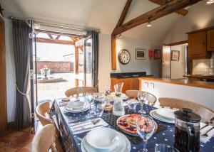 a dining room with a table with plates and glasses at The Old Stables at Humblebee Hall in Worcester