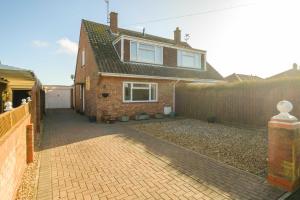 una casa de ladrillo con valla y entrada en 61 Fairfield Road, en Aldeburgh